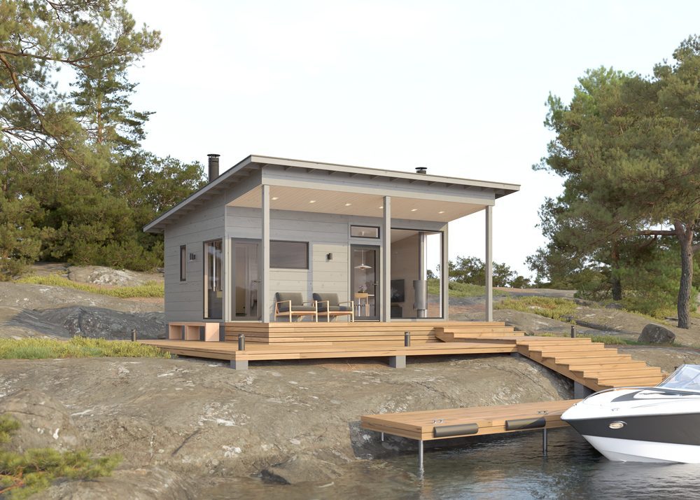 Honkarakenteen pieni saunamökki järven rannalla.