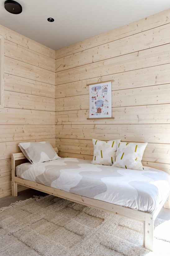 Vaaleaa hirsiseinää ja pieni sohva